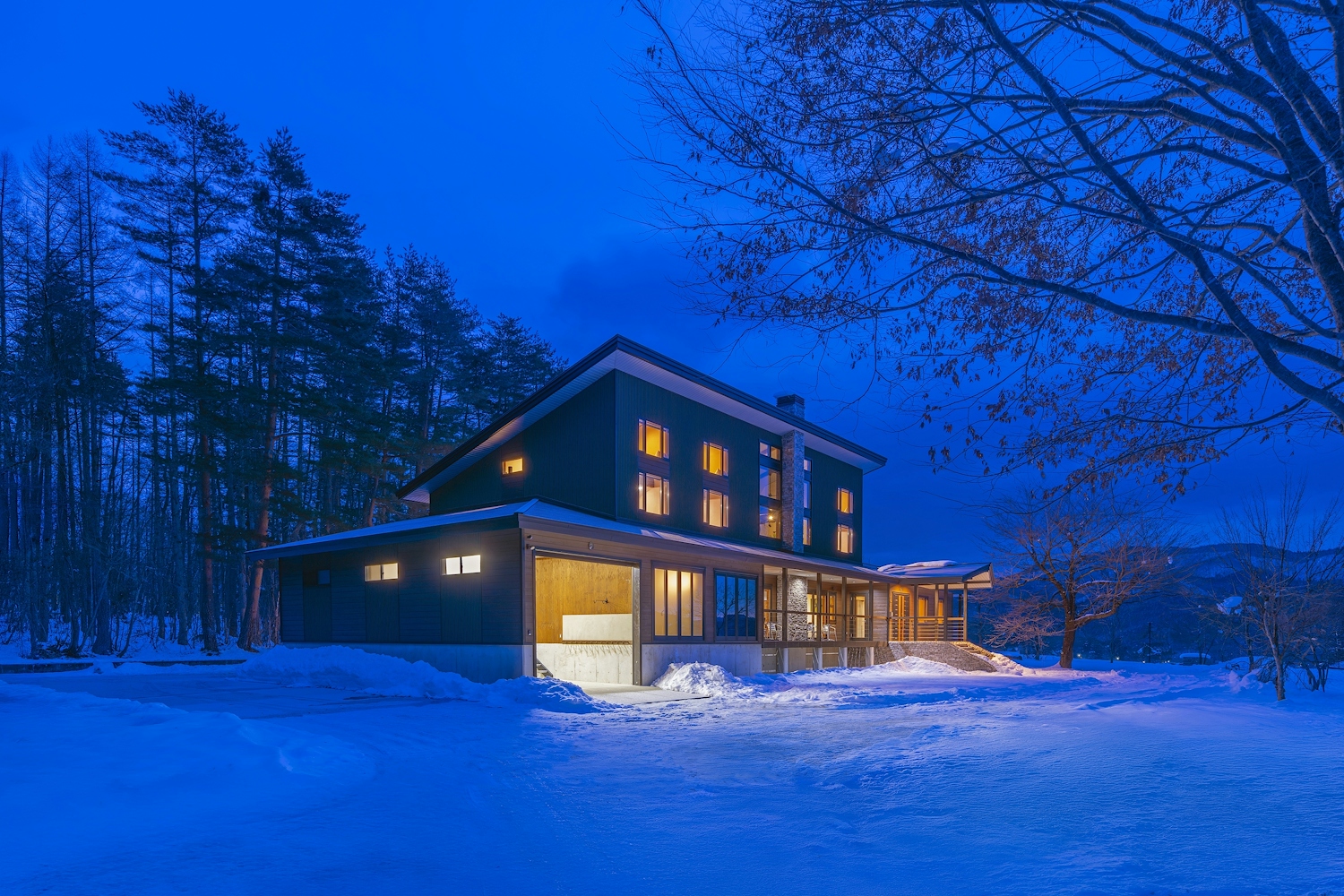 Snow-covered Powderhouse lodge entrance with icicles and a parked car.