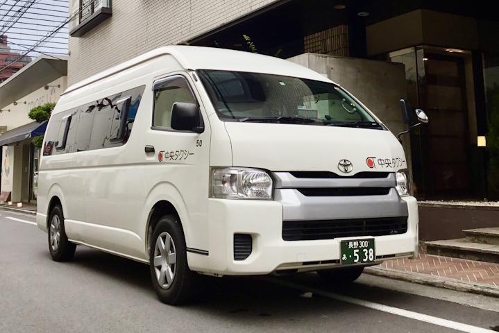 A white Chuo Taxi private transfer van parked on a street.