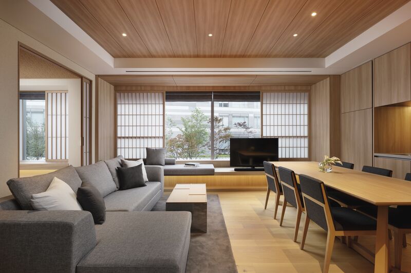 Luxury Japanese-style living room with shoji screens, wood-paneled ceilings, and a large gray sectional sofa.