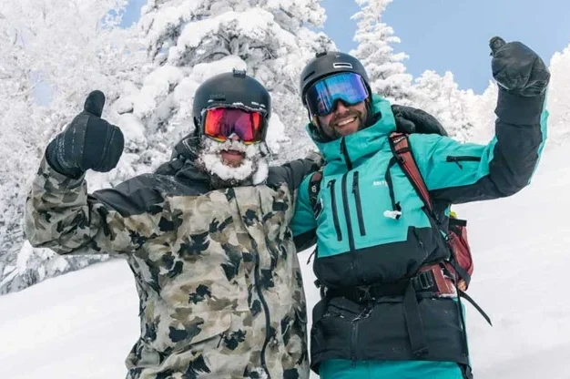 Ski instructor smiling with client.